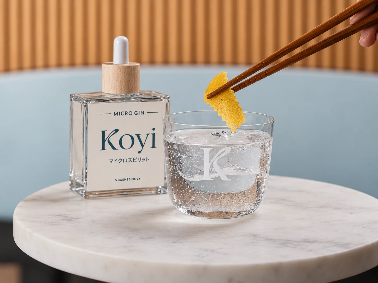 Gin Tonic mit Zitronenzeste neben einer KOYI Micro Gin Flasche
